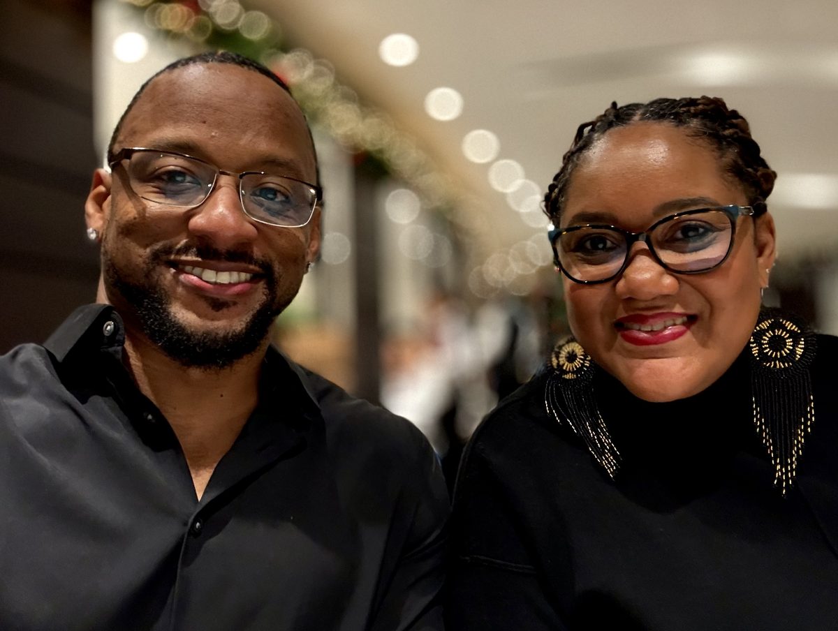 Cedric and Crystal smiling side by side in a candid photo taken while traveling.